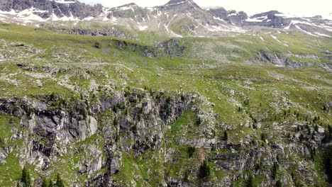 Huge-cliff-in-front-of-a-few-peaks-partly-covered-in-snow-in-the-Alps-in-Kaernten,-Austria