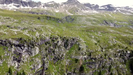 enorme acantilado frente a algunos picos parcialmente cubiertos de nieve en los alpes en kaernten, austria
