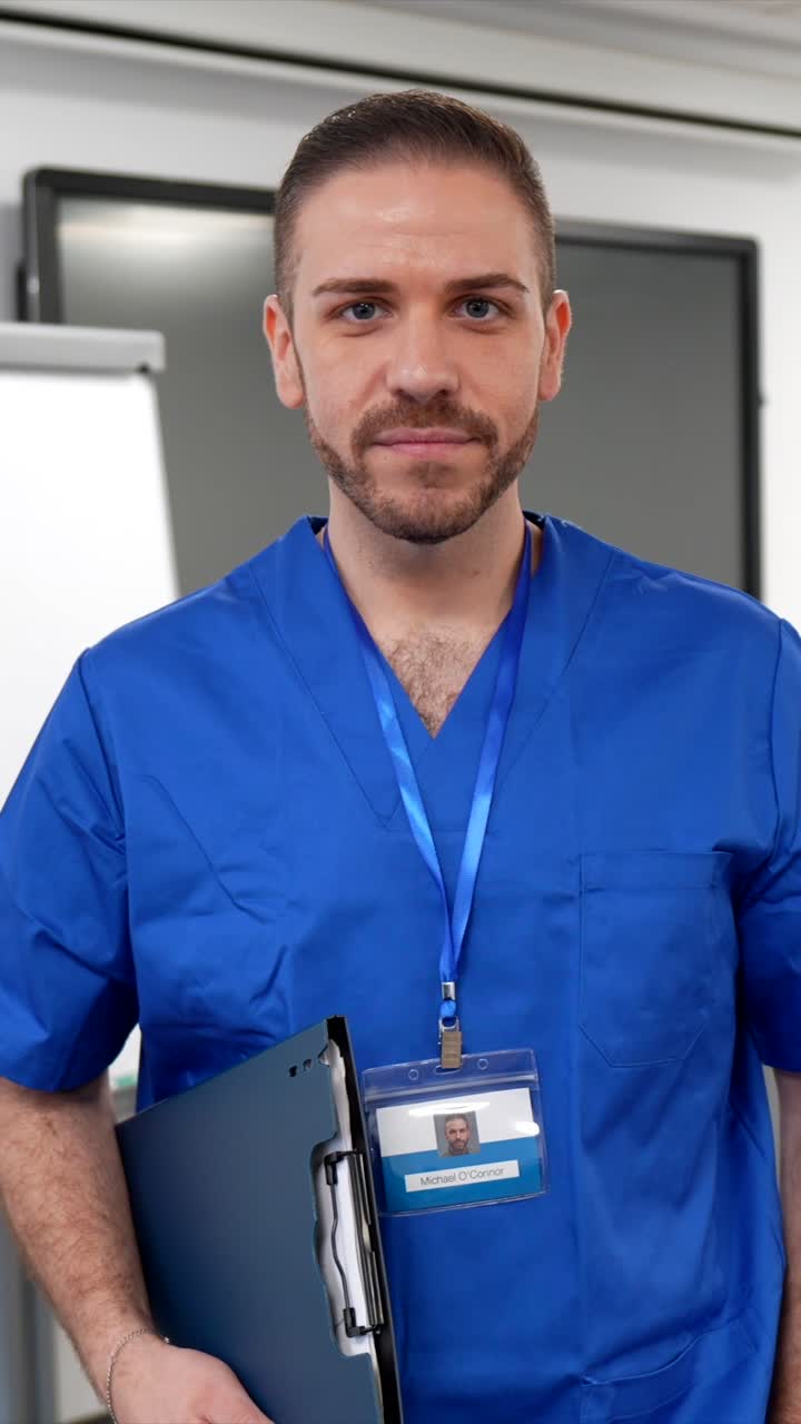 Profesional de la salud masculino con uniforme azul mirando a cámara.