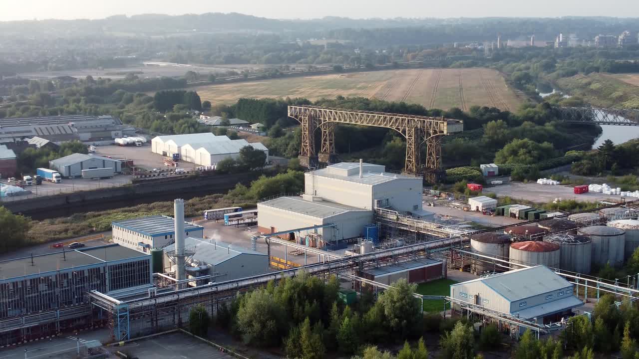 VEDUTA AEREA DEL PAESAGGIO CON LO STORICO PONTE TRASBORDATORE DI WARRINGTON E IL CANALE NAVIGABILE INDUSTRIALE BRITANNICO, IN ALLONTANAMENTO