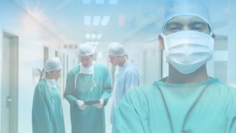 Animation-of-clouds-and-sky-over-surgeons-wearing-face-masks-in-hospital