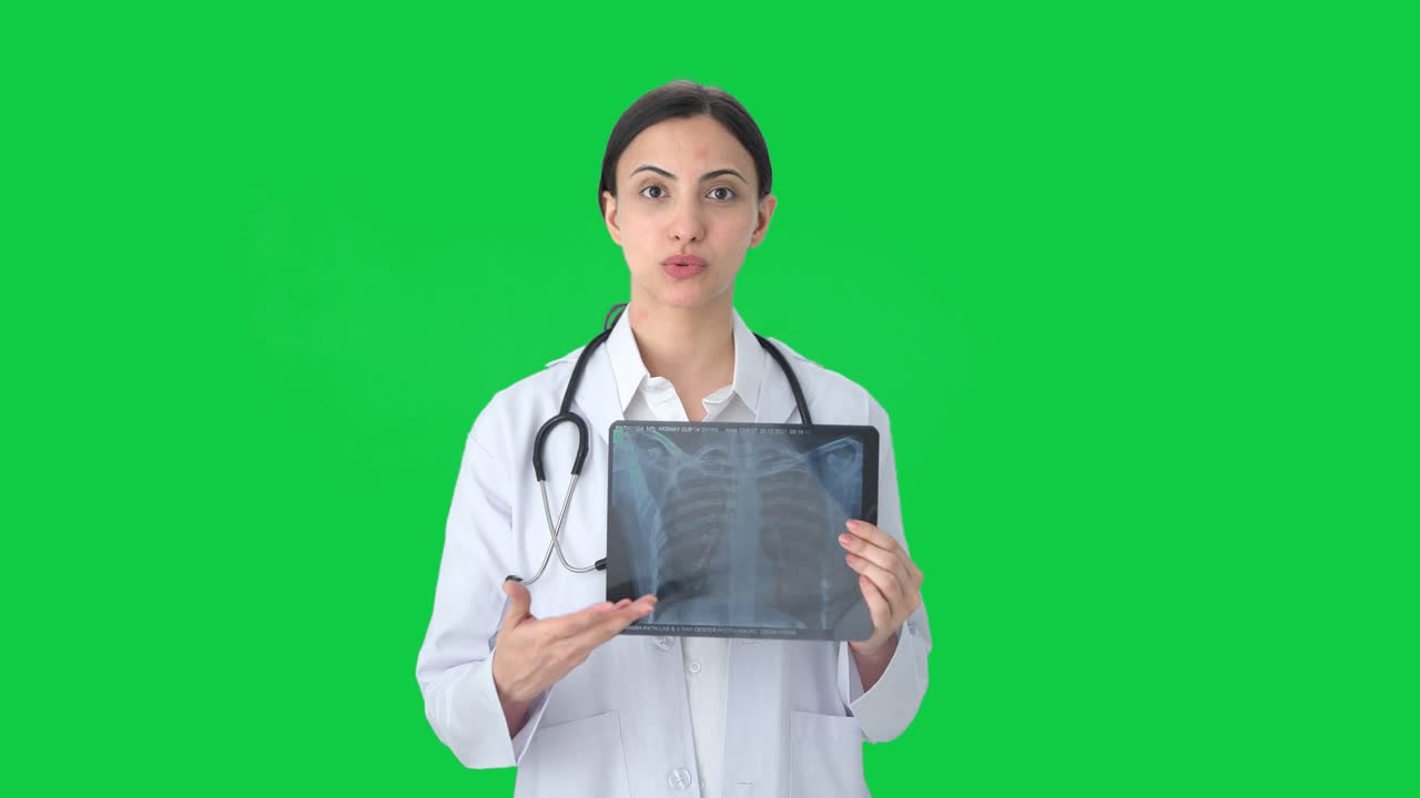 doctora india explicando rayos x a la pantalla verde del paciente