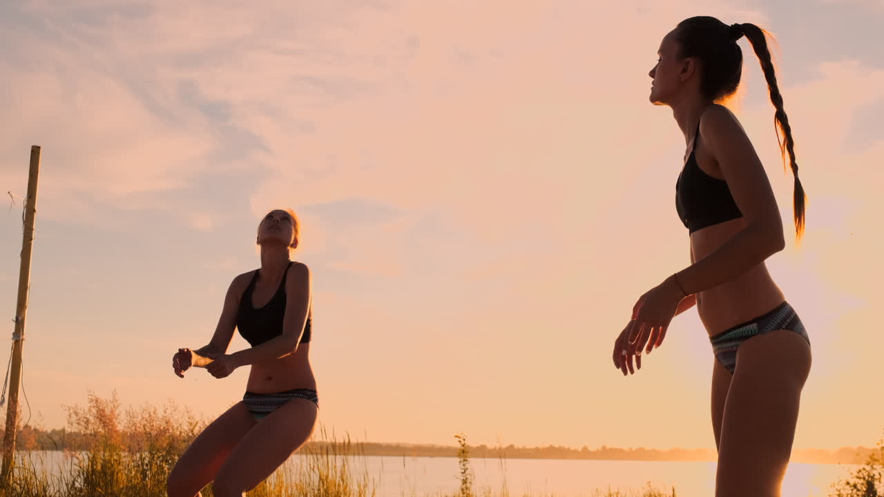 해변에서 아름다운 비키니 소녀들이 슬로모션으로 배구 경기를 합니다.