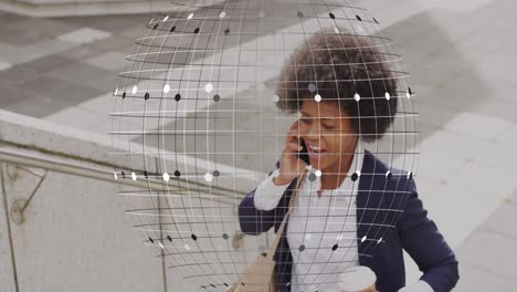 Animation-of-globe-and-business-data-over-african-american-woman-using-smartphone