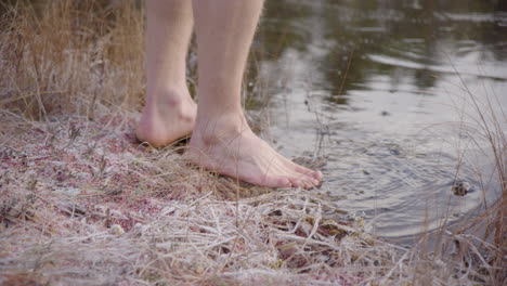 reveal closeup - ice bathers feet approach and start breaking the ice