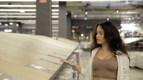 Young Shopper Girl Choosing Wooden Laminate in Building Materials Store