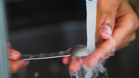 Washing-a-teaspoon-in-slow-motion-in-the-kitchen