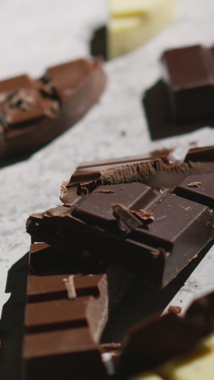 вертикальное видео сломанных батончиков молочного и белого шоколада