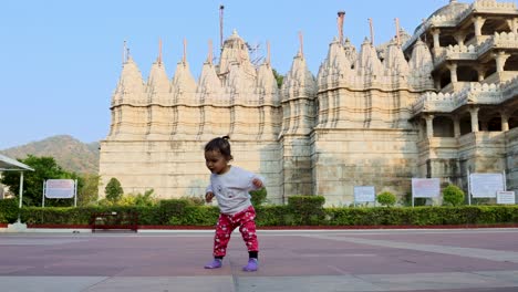 cute toddler walking at temple courtyard at day from unique perspective
