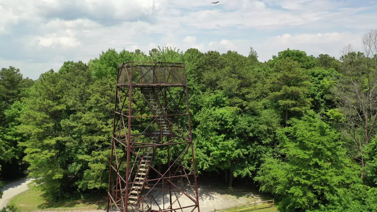 torre de observación del paisaje rodeada de un bosque frondoso y denso, vista de la órbita de los drones