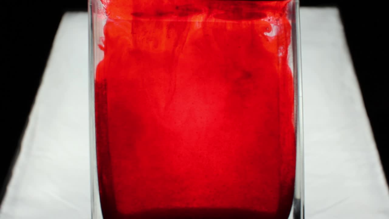 Red chemical is pouring into the water.