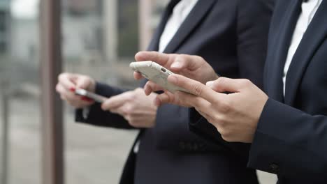 foto recortada de compañeros de trabajo usando teléfonos inteligentes