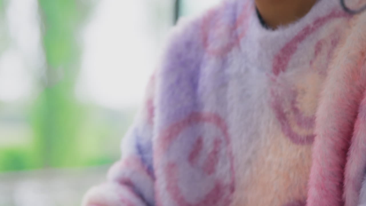 노트북에서 타이핑하는 테이블에 앉아있는 집에서 젊은 여성의 클로즈업