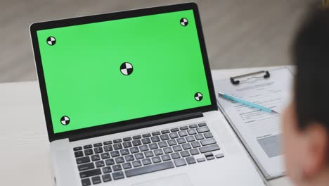 mujer de negocios que tiene una llamada de video en una pantalla verde en un lugar de trabajo remoto. mujer médico profesional hablando durante una videoconferencia en una computadora portátil con llave chroma en la oficina