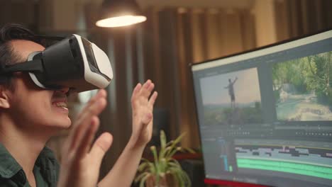 asian male video editor using a vr headset while works with footage and sound on his personal computer, he works late at night