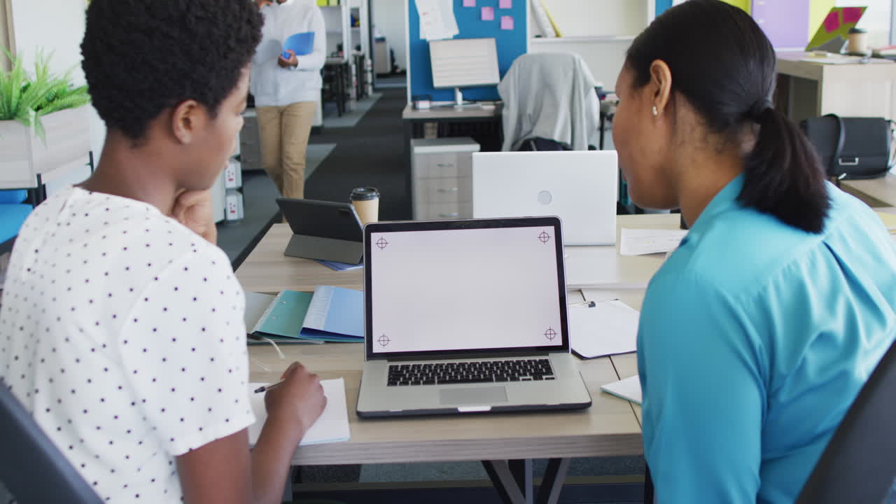 African american business people using laptop with copy space at office, slow motion
