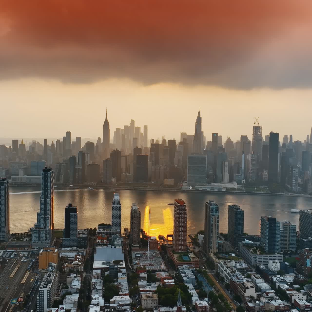 Manhattan in the haze of sunset. New York skyline under the orange cloudscape. Top view