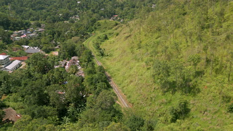 Establishing-Aerial-Drone-Shot-of-Train-Pulling-Up-Demodara-Loop-on-Sunny-Day-in-Sri-Lanka