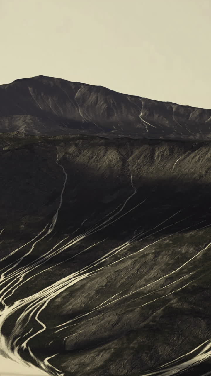 Mountains with winding paths under a clear sky at sunset