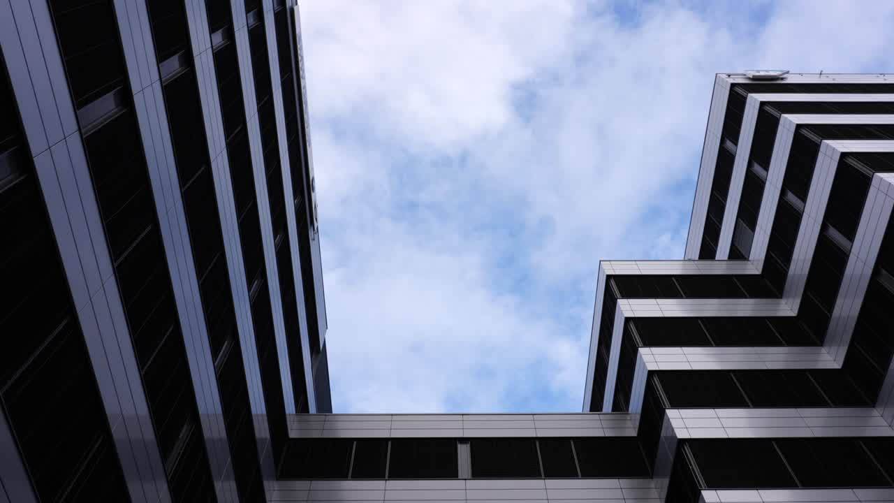 disparo estático del exterior del edificio de oficinas moderno mientras las nubes blancas se mueven