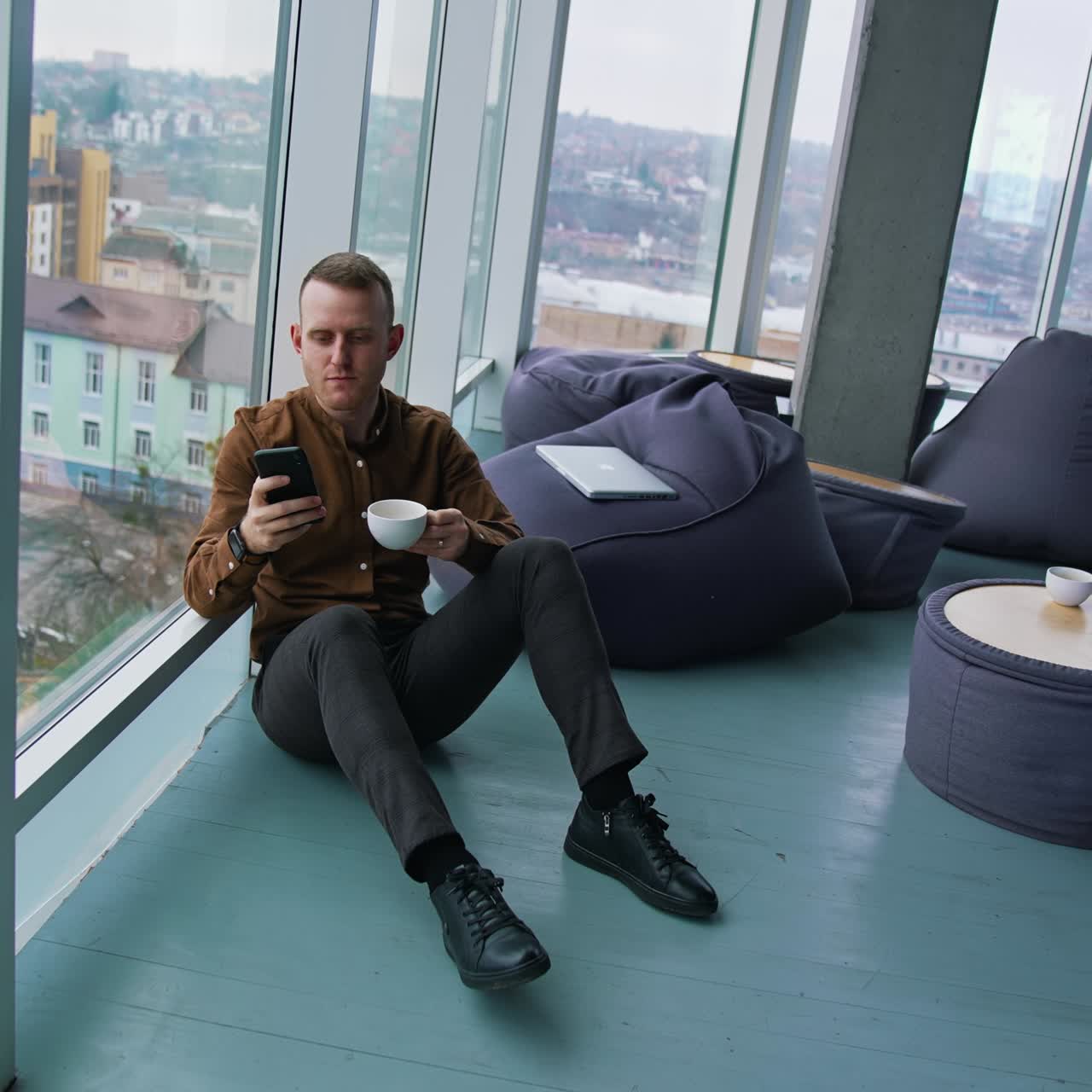 Handsome man talking on mobile phone and drinking coffee
