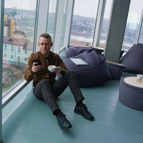 handsome man talking on mobile phone and drinking coffee