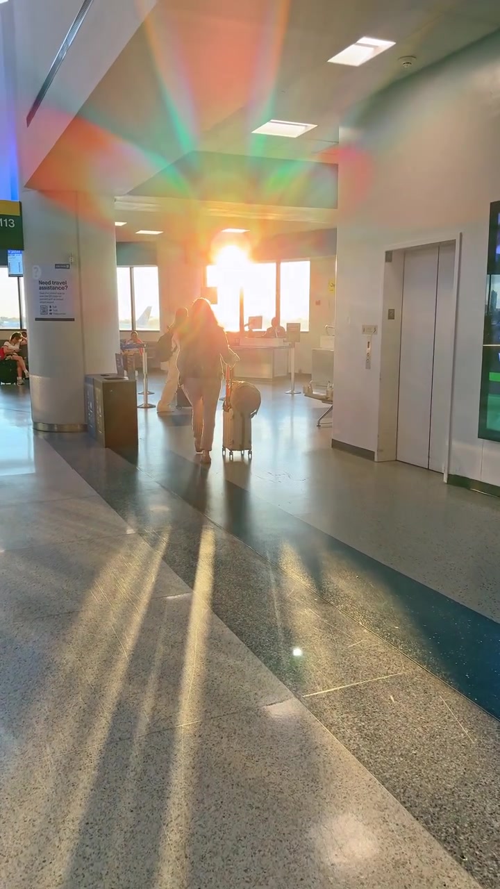 Tulum, México, 1 de agosto de 2025: La luz del sol brilla a través de un aeropuerto mientras un viajero camina con equipaje