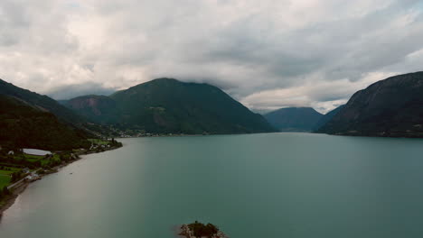 Drone flying over Lustrafjorden, Norway in the summer with a small island in the middle of the fjord