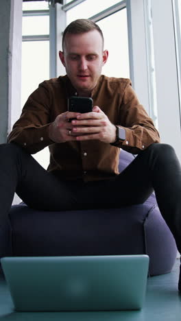 young man with laptop and mobile phone. man an is working remotely vertical video