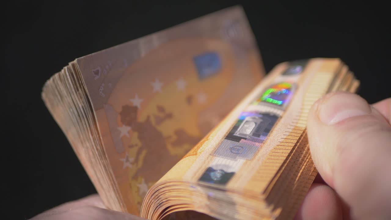 한 사람의 손에 든 50유로 지폐 다발