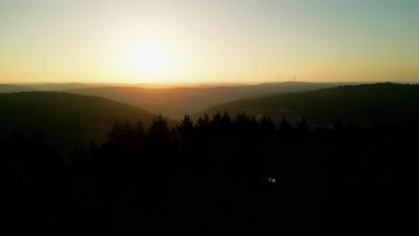 sunrise from drone over a forest passing a tower