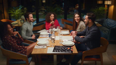 Jóvenes-Divirtiéndose-En-El-Restaurante.-Amigos-De-Raza-Mixta-Disfrutan-De-La-Noche-En-La-Cafetería.