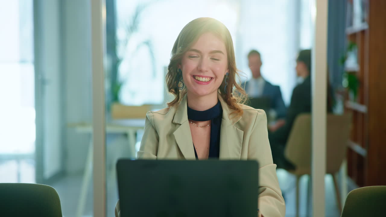 A smiling businesswoman working on her laptop in an office