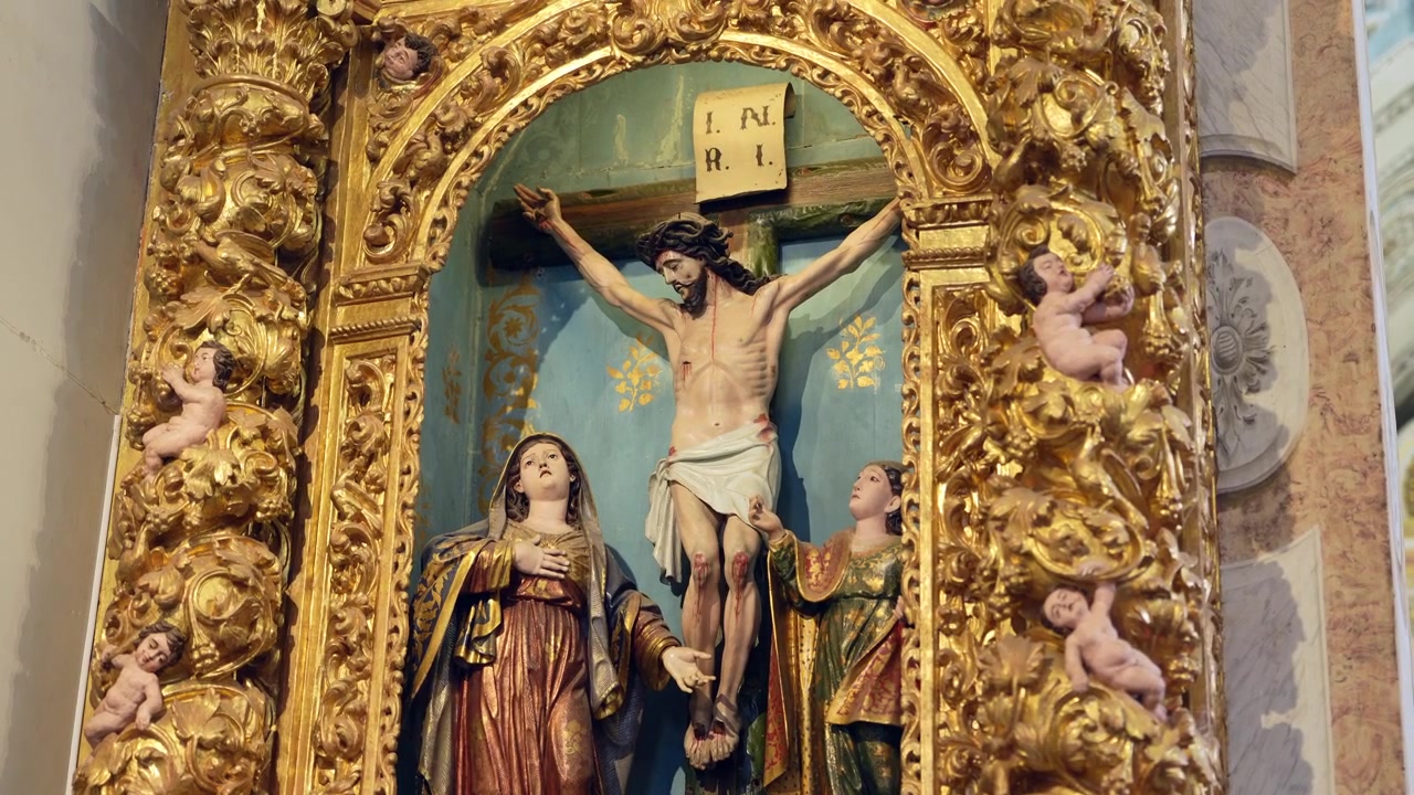 Altare dorato ornato raffigurante la crocifissione di Gesù Cristo affiancato dalla Vergine Maria e San Giovanni in una chiesa