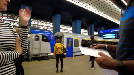 people talking with passengers waiting on the platform