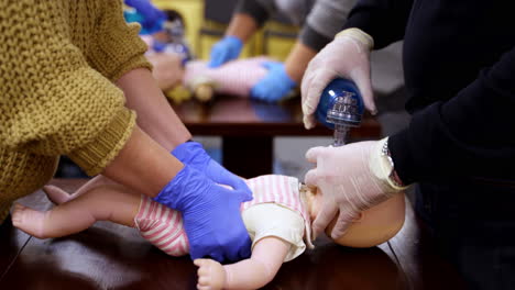 demonstrating chest compressions on medical infant dummy doll. simulator for training first aid. heart massage training. concept of medical education and practice.