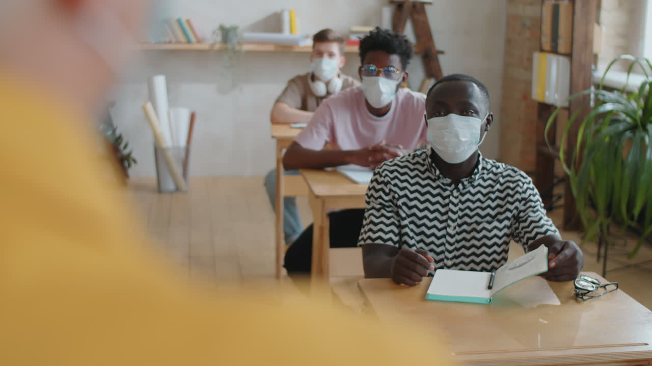 Afro-American Student in Mask Talking with Teacher on Lesson