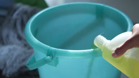 pouring cleaning solution into a bucket