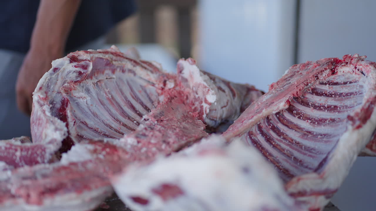 Butcher salting fresh lamb meat, enhancing flavor while ensuring preservation for future culinary creations. Engaging in traditional techniques, showcasing expertise in food processing