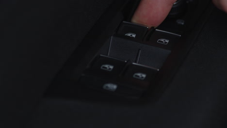 Close-up-pressing-the-up-and-down-window-buttons-on-a-car