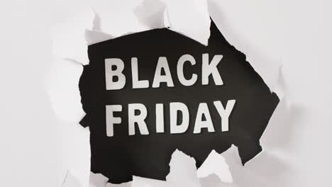 ripped white paper over black friday text in white on black background