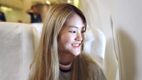 Mujer-Asiática-Feliz-Viajando-En-Avión