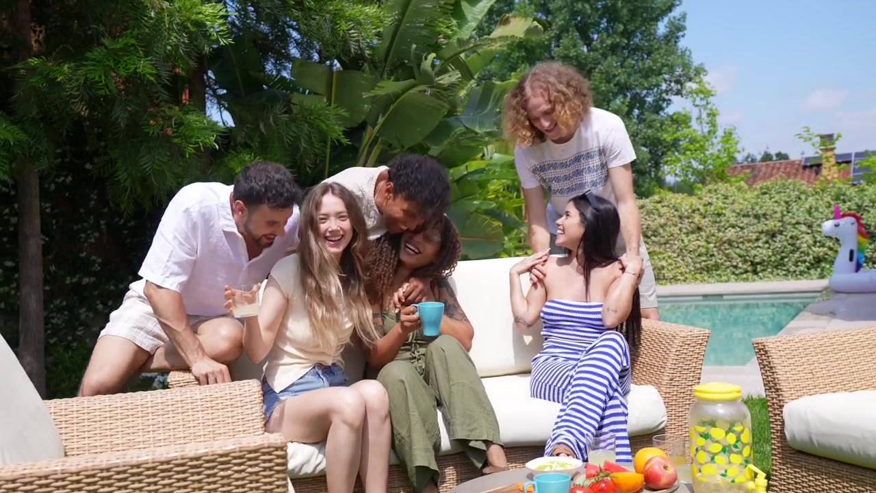 Amici felici che socializzano e gustano spuntini su una terrazza soleggiata