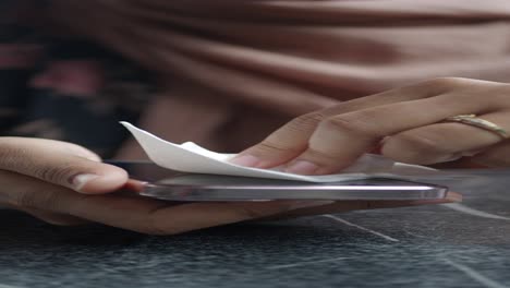 woman cleaning her smartphone screen with a wipe