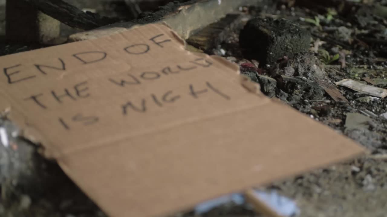 End of the world handwritten sign left in dirt and rubble