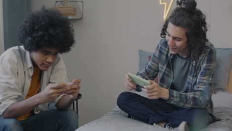 two teenagers playing games on smartphones