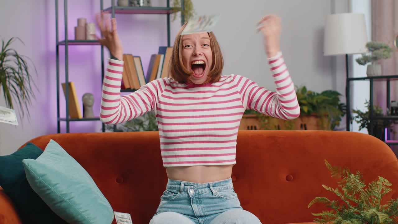 Money cash dollar rain falling on girl celebrating success winning good news lottery jackpot luck
