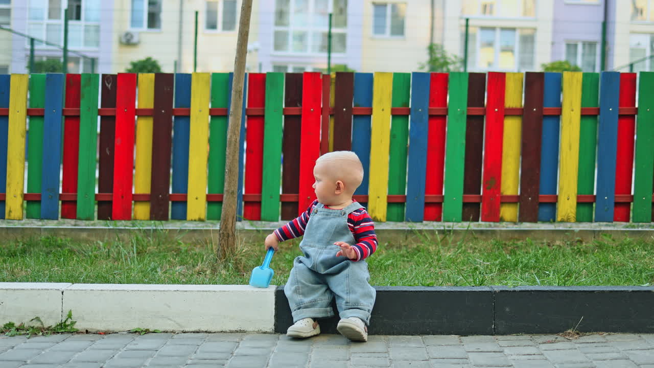 Lachender und spielender kleiner Junge auf dem Spielplatz. Kind spielt auf einem öffentlichen Spielplatz an einem sonnigen Sommertag. Lebensstil. Spazierendes Kind im Freien.