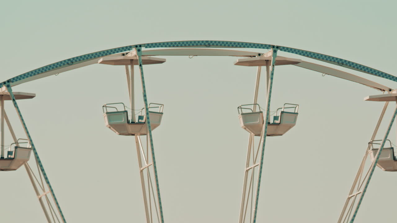 Close up of the Ferris wheel cabins and metal beams, emphasizing the geometric lines