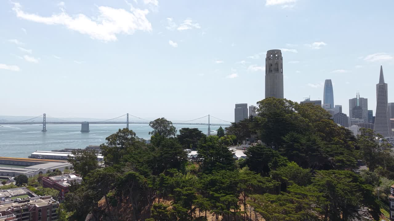 Drone Shot of Coit Tower and Oakland Bay Bridge on Sunny Day in San Francisco, California USA